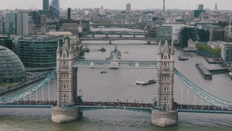 Large-crowd-of-marathon-runners-cross-the-famous-London-Tower-Bridge,-aerial-establishing