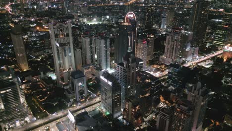 Luftaufnahme-Der-Skyline-Der-Stadt-Mit-Modernem-Wolkenkratzergebäude,-Das-Nachts-Beleuchtet-Ist