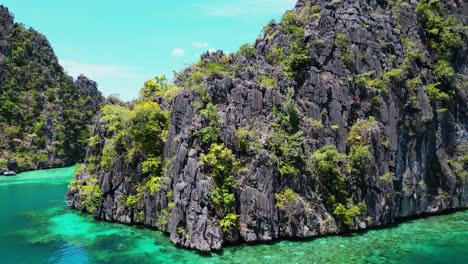 Drone-Ascendiendo-Por-Encima-De-Barcos-Junto-A-Las-Montañas-En-El-Lago-Kayangan