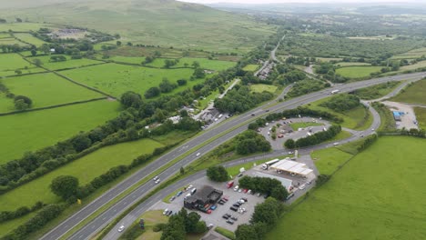 Luftaufnahme-Des-Verkehrs-Auf-Der-A30,-Die-Durch-Die-Ländliche-Landschaft-Von-Devon,-Großbritannien,-Führt-Und-Felder-Und-Landschaft-Zeigt