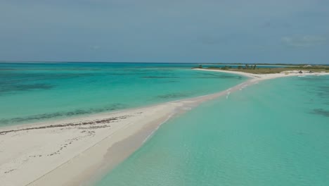 Slow-drone-shot-of-the-sand-bar-between-two-tropical-islands-Cayo-Agua-in-Los-Roques,-Venezuela