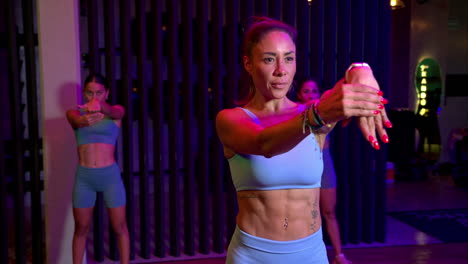 Slow-motion-of-a-group-of-three-brunette-mexican-latin-sportswomen-doing-stretch-moves-to-enhance-the-mobility-on-their-wrists