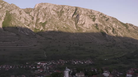 Vista-Aérea-Del-Pueblo-De-Rimetea-Con-Las-Montañas-Piatra-Secuiului-Al-Fondo-En-Rumania