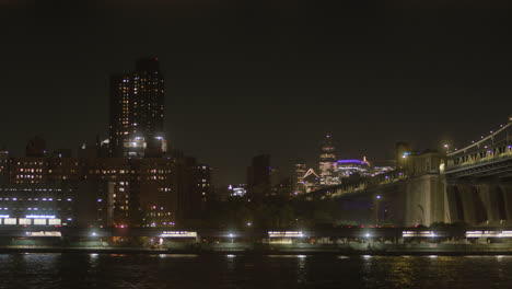 street-establishment-shot-of-Brooklyn-bridge-at-night,-skyline-of-New-York,-NYC-citylights,-angled-view