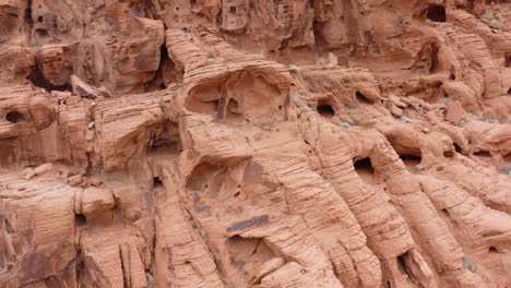 Eine-Drohne-Fliegt-über-Einen-Geologischen-Roten-Stein-Und-Enthüllt-Die-Struktur-Und-Löcher