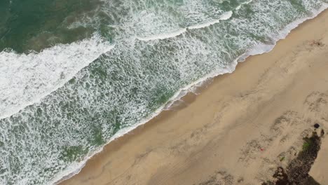 Lange,-Friedliche-Shorebreak-Wellen-Verteilen-Das-Wasser-über-Den-Flachen-Strand-Von-Puerto-Escondido,-Oaxaca,-Mexiko,-Drohne-Von-Oben-Nach-Unten