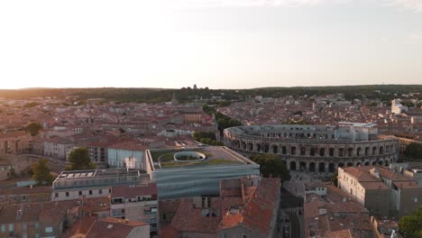 Luftaufnahme-Von-Nîmes-Mit-Dem-Antiken-Römischen-Amphitheater,-Arènes-De-Nîmes,-Bei-Sonnenuntergang