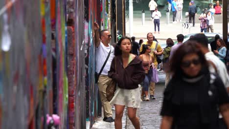 Touristen-Besuchen-Hosier-Lane,-Eine-Beliebte-Kopfsteinpflastergasse-Mit-Einer-Lebendigen-Palette-An-Kunstwandmalereien-Und-Graffiti-An-Den-Wänden,-Eine-Kreative-Kulturelle-Straßenszene-In-Der-Stadt-Melbourne