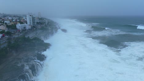 Aerial-flyover-foamy-coastline-of-city-in-Dominican-Republic-during-foggy-day