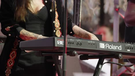 Tattooed-female-musician-plays-keyboards-energetically,-Stampede-Stage