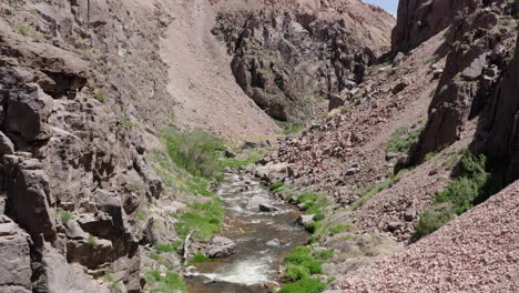 A-serene-river-flows-through-a-rocky-canyon-in-Alabama-Hills-under-clear-blue-skies