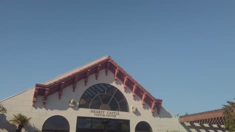 Gimbal-close-up-booming-down-shot-of-the-entrance-to-the-Hearst-Castle-Visitor-Center-in-San-Simeon,-California