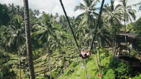 Encantadora-Pareja-Montando-Un-Columpio-Icónico-En-El-Fragante-Bali-De-Tegallalang,-Bali,-Indonesia