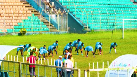 Young-boys-of-junior-team-warming-up-together-for-football-match-or-training-on-an-outdoor-stadium