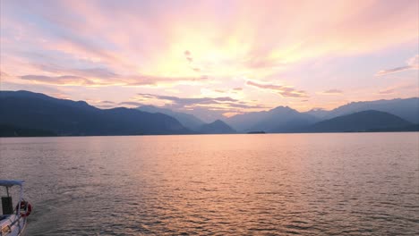 Cinematic-reverse-aerial-of-sailboat-at-sunset-on-Lake-Maggiore-with-mountains