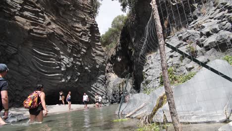 People-enjoying-a-vacation-at-Taormina-walking-in-the-water