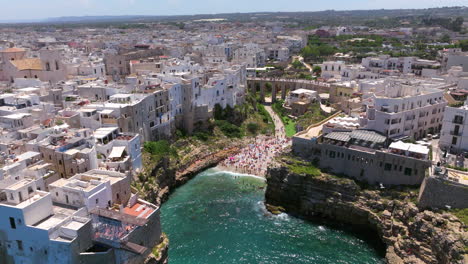 Overview-Of-People-Swims-On-Lama-Monachile-On-The-Coast-Town-Of-Polignano-a-Mare-During-Summer-In-Bari,-Italy