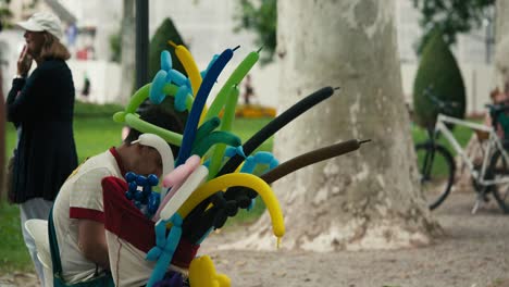 person-sitting-with-a-bundle-of-colorful-balloon-animals-at-Zagreb's-Cest-is-d'Best-street-festival