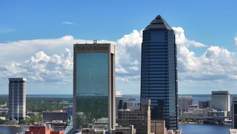 Rising-drone-shot-of-mirrored-Wells-Fargo-Tower-during-sunny-day-in-Jacksonville,-Florida