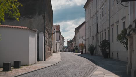 Quiet,-sunlit-cobblestone-street-lined-with-historic-buildings-in-Varaždin,-Croatia