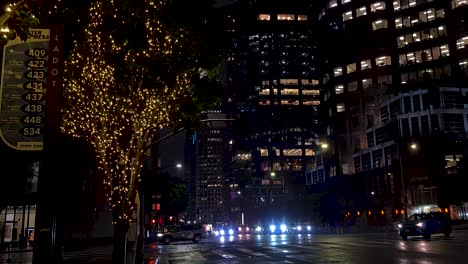 Downtown-Los-Angeles-at-Night-During-Christmas-Holidays,-Lights-on-Trees,-Towers-and-Street-Traffic