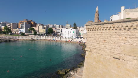 Gente-De-Vacaciones-En-Cala-Porta-Vecchia,-Junto-Al-Mar-De-La-Ciudad-De-Monopoli-En-Apulia,-Italia