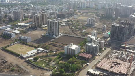 Cámara-De-Drones-Que-Muestra-Muchas-Casas-De-Vecindad-Y-Un-Gran-Sitio-De-Construcción-En-Marcha.