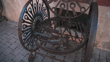 Primer-Plano-De-Una-Silla-De-Metal-Ornamentada-Con-Intrincados-Diseños-Circulares-Y-Detalles-Rústicos,-Ubicada-En-Una-Calle-Adoquinada-En-Varaždin,-Croacia