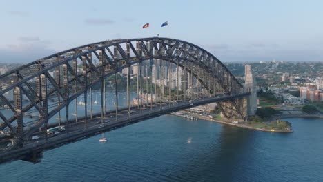 SYDNEY,-AUSTRALIA---APRIL-1,-2024:-aerial-drone-shot-of-Harbour-Bridge,-a-famous-steel-arch-bridge,-panning-motion-revealing-the-sea-and-the-cityscape