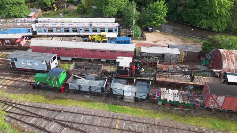 Vista-Aérea-De-Ironstone-Railway-Trust-Locomotoras-En-Desuso,-Vagones-De-Carga-Y-Camiones-De-Tren