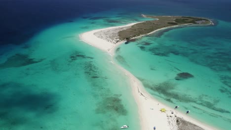 A-pristine-turquoise-beach-with-a-narrow-sandy-path-connecting-two-islands,-aerial-view