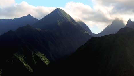 Goldener-Sonnenaufgang-Hoch-Aufragende-Berge-Gipfel-Parallaxe-Sonnenaufgang-Teahupoo-Tahiti-Luftdrohne-Französisch-Polynesien-Sonnenblendung-Wolken-Südpazifik-Brandungswellenriff-Kanal-WSL-Surfen-Olympia-Austragungsort-Kreis-Rechts