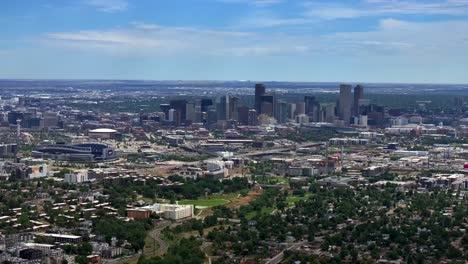 Summer-downtown-Denver-Colorado-aerial-drone-Mile-High-city-skyscrapers-neighborhood-homes-blue-skies-cloudy-6th-avenue-colfax-RTD-line-front-range-foothills-landscape-circle-left-motion