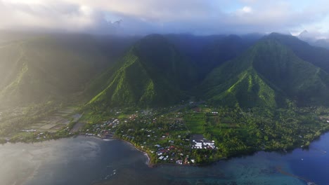 Golden-Hour-Haze-rain-clouds-layer-Teahupoo-Tahiti-aerial-drone-island-view-perspective-French-Polynesia-coastline-2024-surf-Pacific-Ocean-Golden-Hour-Point-Faremahora-Pass-Havae-forward-pan-up