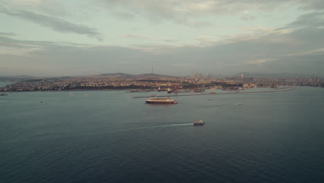 Drone-view-of-sailing-ships-near-harbor-in-Istanbul-city-with-cloudy-sky,-Türkiye