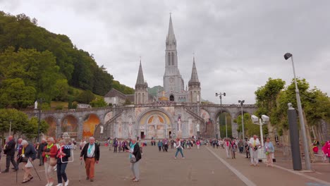 Catholic-pilgrims-visiting-Lourdes-in-South-West-France,-view-on-the-main-square-of-the-Sanctuary-of-Our-Lady-of-Lourdes-called-rosary-square