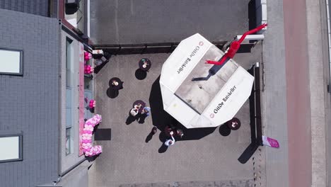 Top-down-aerial-above-small-business-event-opening-with-a-skydancer