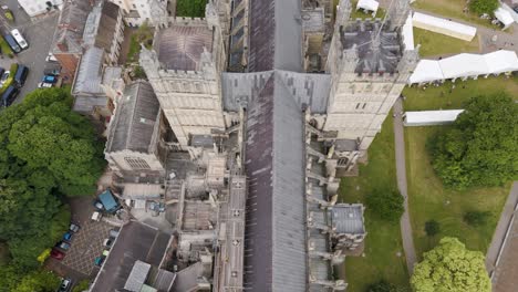 Aerial-pull-out-revealing-the-grand-Exeter-Cathedral-amidst-the-historic-charm-of-Exeter,-Devon,-UK,-July-2024