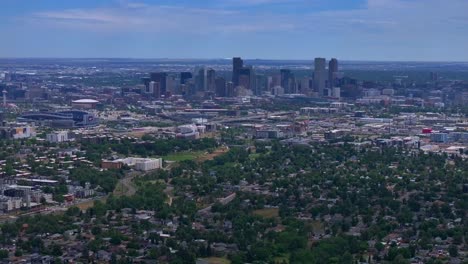 Summer-downtown-Denver-Colorado-aerial-drone-Mile-High-city-skyscrapers-neighborhood-homes-blue-skies-cloudy-6th-avenue-colfax-RTD-line-front-range-foothills-landscape-forward-parallax-motion