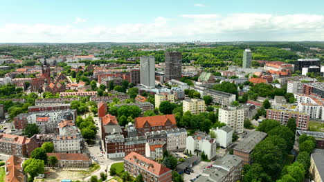 Aerial-view-of-a-residential-area-in-Gdańsk,-featuring-a-mix-of-modern-and-traditional-buildings,-lush-greenery,-and-city-skyline