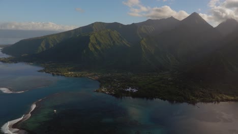 Golden-sunrise-Teahupoo-Tahiti-aerial-drone-French-Polynesia-sun-glare-clouds-South-Pacific-towering-mountainscoast-sunrise-judge-tower-surf-wave-reef-channel-WSL-surfing-Olympic-venue-circle-left