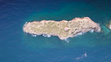 Vista-Aérea-De-La-Pequeña-Isla-De-Piedra-Caliza-De-Punta-Del-Toro-En-Aguas-Turquesas,-España