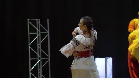 Traditional-dance-of-the-otavalo-culture,-andean-folklore,-Ecuador,-group-of-people-dancing,-wearing-cultural-costumes-and-performing-happily-on-the-stage