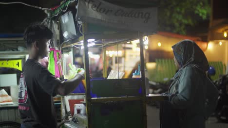 Joven-Vendiendo-Comida-Callejera-Por-La-Noche-En-La-Plaza-Ahmad-Yani-En-La-Ciudad-De-Tangerang,-Indonesia