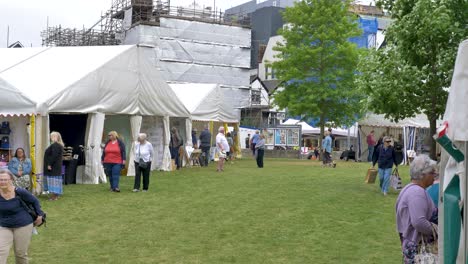 Tiendas-De-Campaña-Que-Albergan-El-Mercado-Local-Con-Visitantes-Fuera-De-La-Catedral,-Exeter,-Devon,-Reino-Unido,-Junio-De-2024.