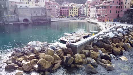 Couple-enjoying-the-view-from-Vernazza-harbor,-Aerial-Pan