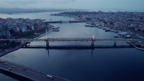 Gloomy-drone-flight-over-a-big-river-in-Istanbul,-focussing-on-a-brigde-with-traffic-on-a-cloudy-day,-birdseye-with-copy-space