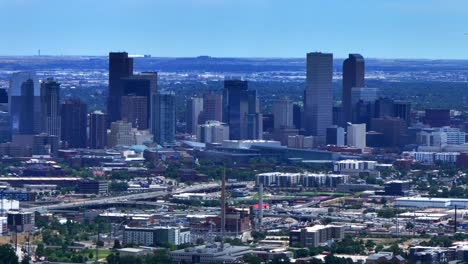 Summer-downtown-Denver-city-skyscrapers-Colorado-aerial-drone-traffic-cars-highway-Mile-High-neighborhood-homes-blue-skies-cloudy-6th-avenue-colfax-RTD-line-front-range-foothills-landscape-circle-left