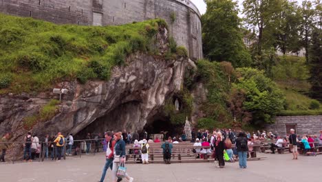 Pilgrims-visiting-the-Grotto-of-Massabielle-in-the-Sanctuary-of-Our-Lady-of-Lourdes,-South-West-of-France