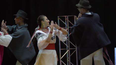 Traditioneller-Tanz-Der-Otavalo-Kultur,-Andenfolklore,-Ecuador,-Gruppe-Von-Männern-Und-Frauen,-Die-Kulturelle-Kostüme-Tragen-Und-Fröhlich-Auf-Der-Bühne-Auftreten